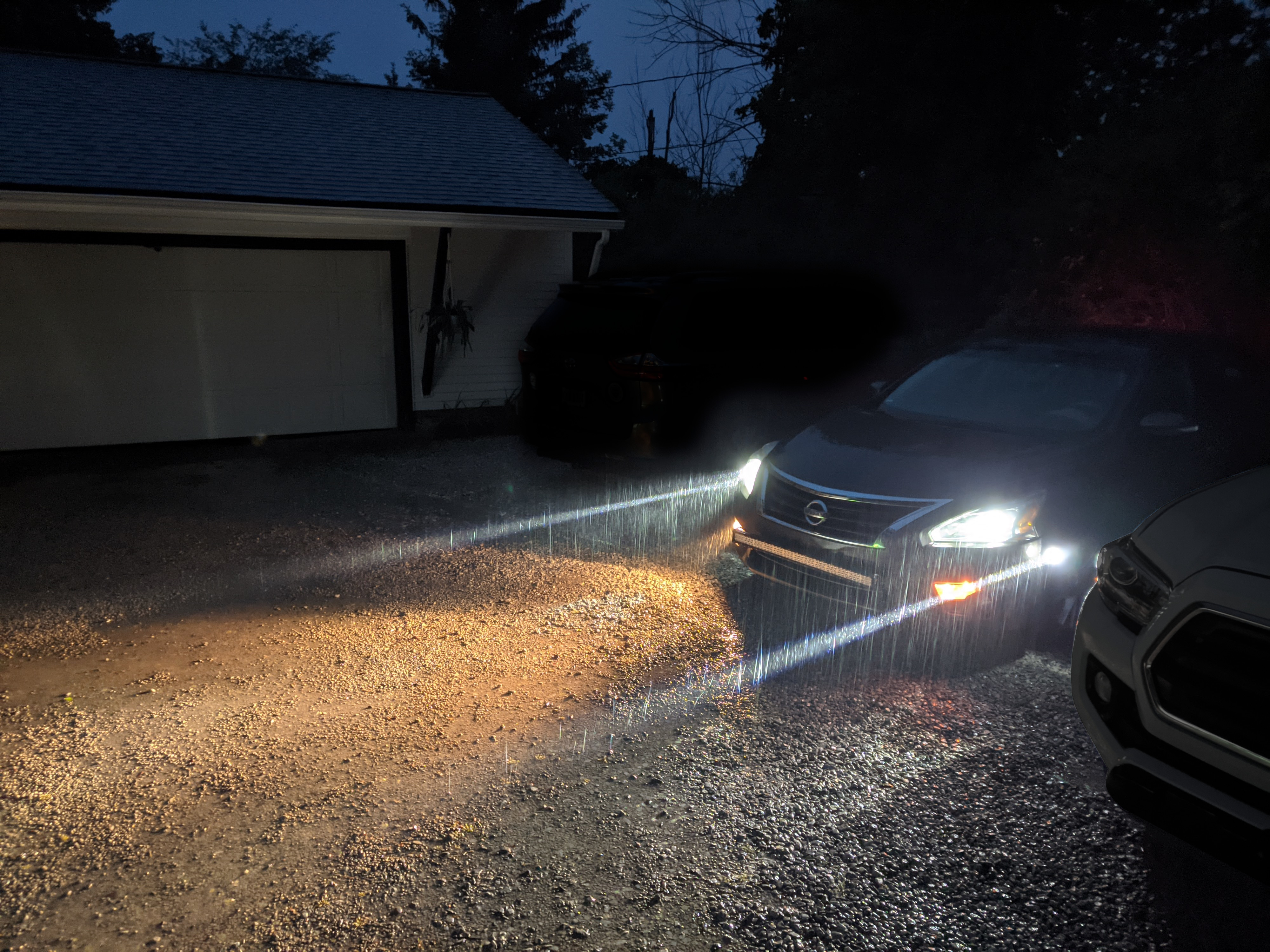 Overhead view of a sedan in the dark with the headlights and 4 perimeter lights illuminating the surrounding area.