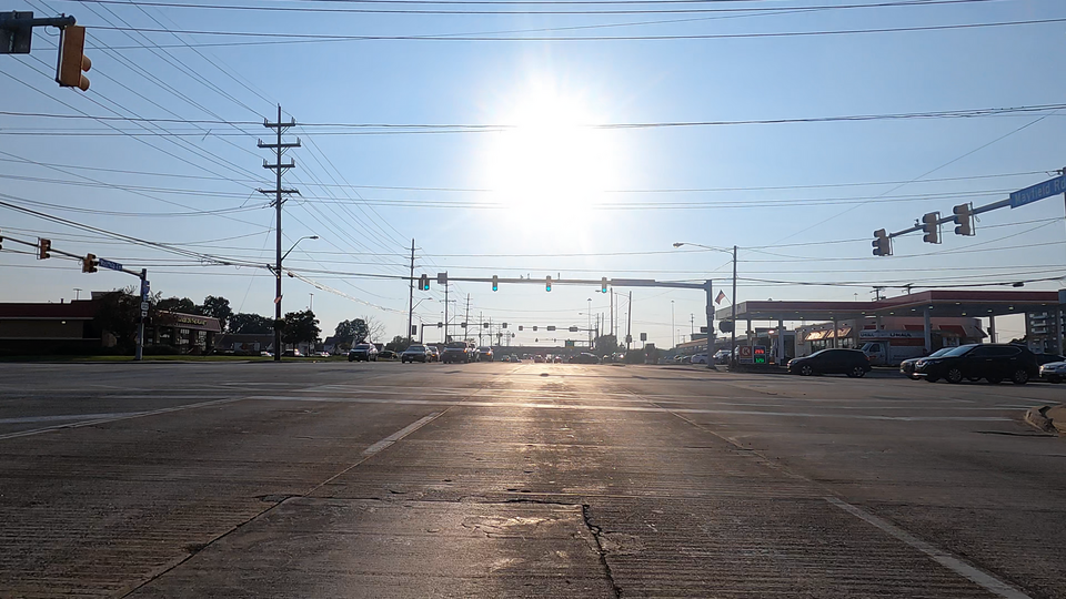 A picture of a large road intersection with a traffic light