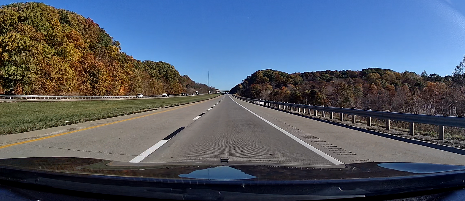 A screenshot of dashcam video taken while driving down a scenic, mostly empty divided highway.