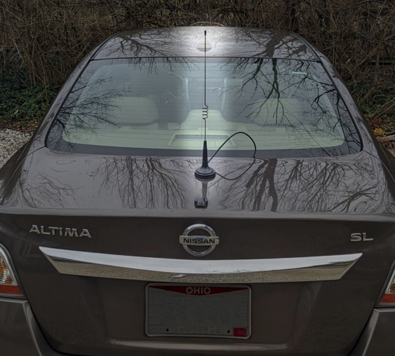 A thin, black, 18 inch antenna on the trunk of a Nissan Altima