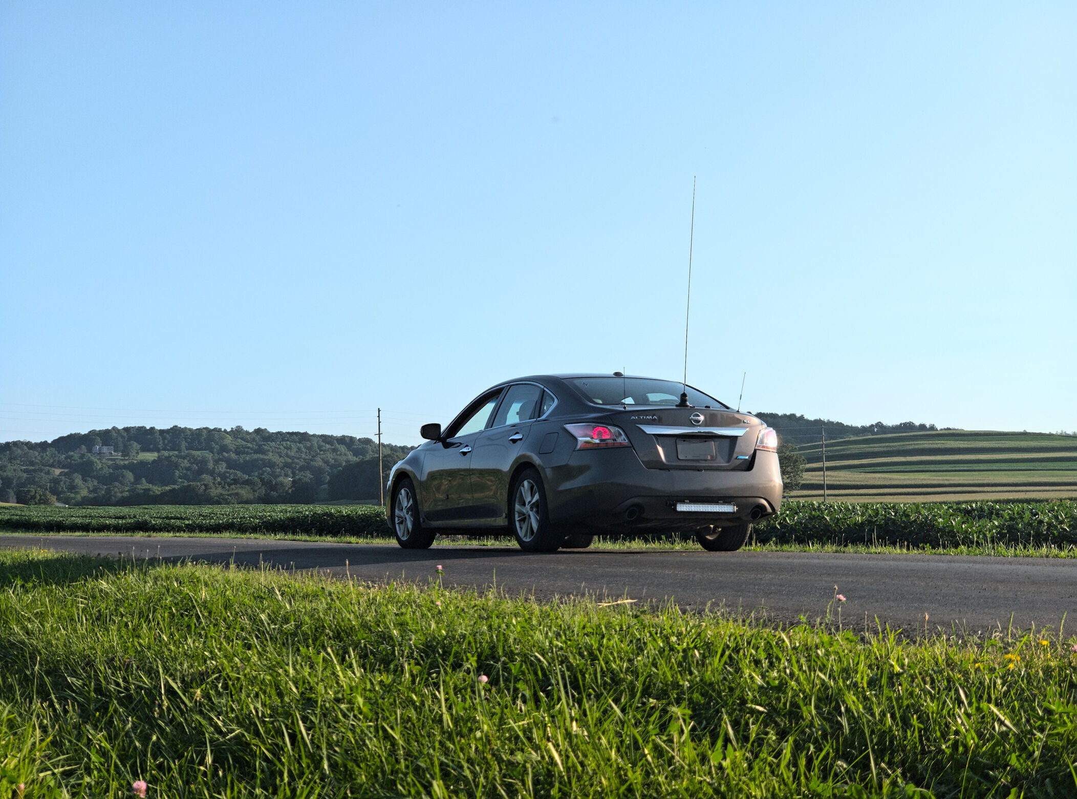 A tall, silver, 62 inch antenna in the center of the trunk of a Nissan Altima